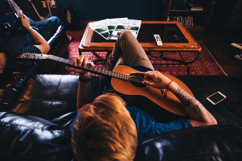 Trevor Hall plays guitar at home. Photo by Emory Hall. LA YOGA