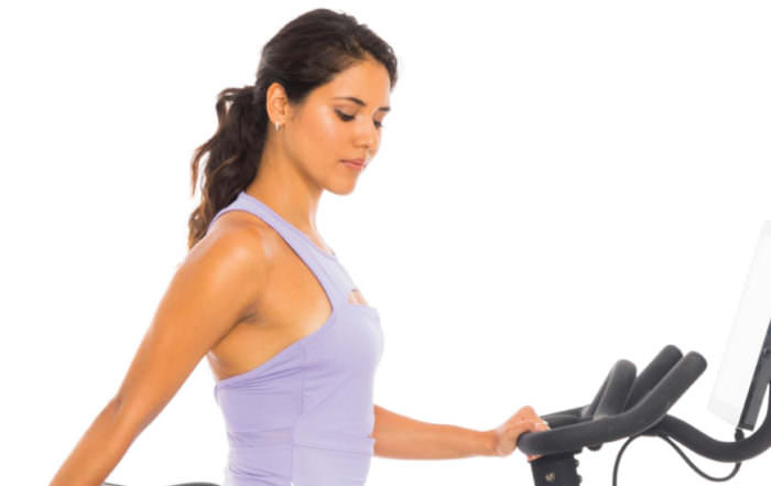 Yoga Fashion and Fitness Imuri Pacheo stretching with Peloton bike