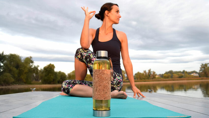 Woman practicing yoga with tea 