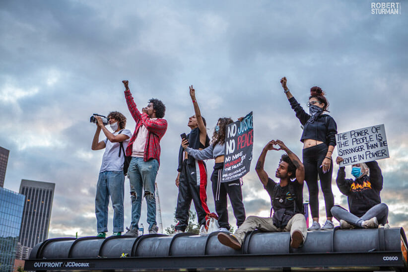 demonstrators in LA on top of a bus stop 