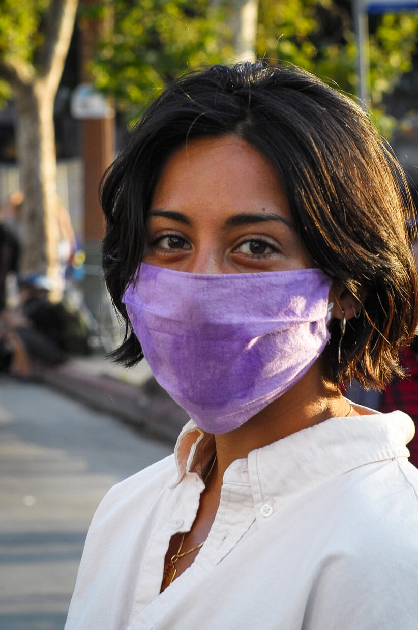 Woman with purple mask at City Hall.