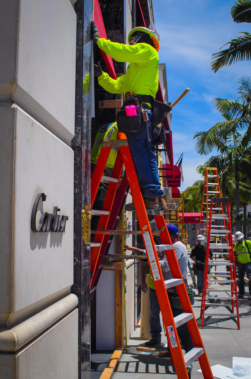 Laborer repairs damage at Cartier in Beverly Hills, CA.