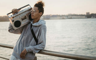 young man holding boom box music for manifestation