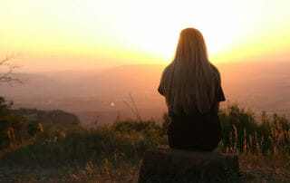 person sitting at sunset understanding meditation