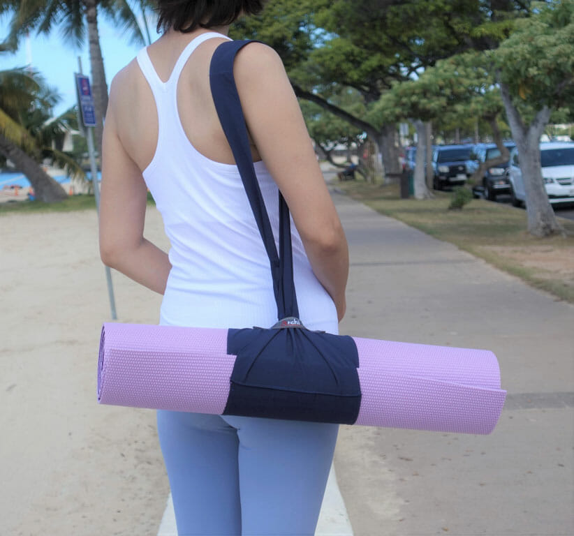 Person on street with roll up and carry yoga mat carrier
