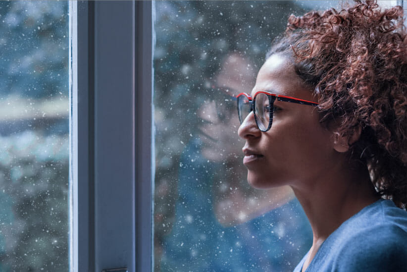 woman looking out window to reflect on how to prioritize growth