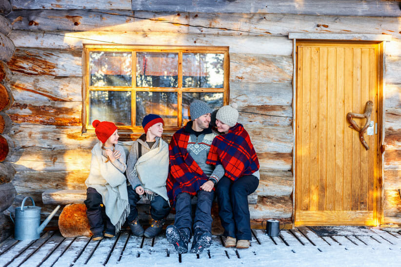 family outside a cabin demonstrating how to declutter your holidays