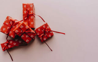 gift boxes with hearts on the wrapping paper to showcase gift guide for yoga men