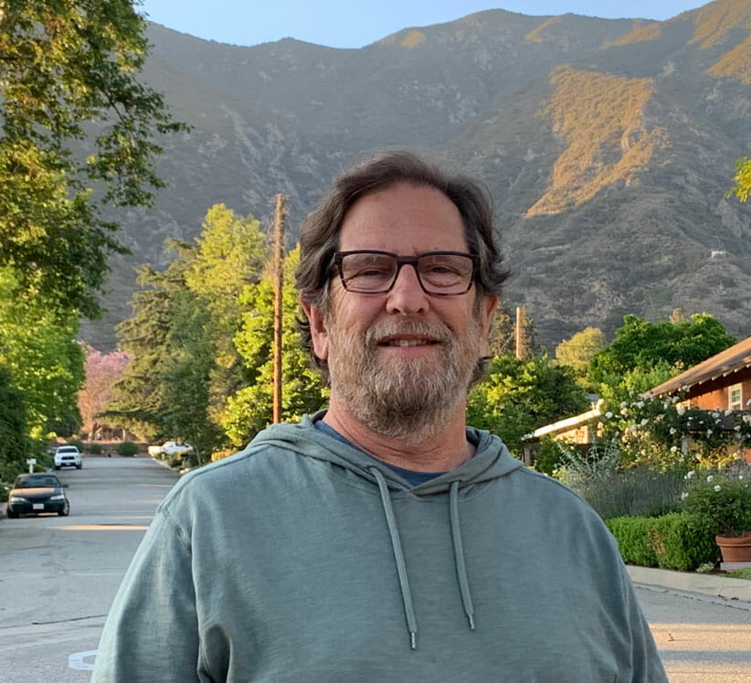 Larry Mangel man wearing blue shirt in front of mountains