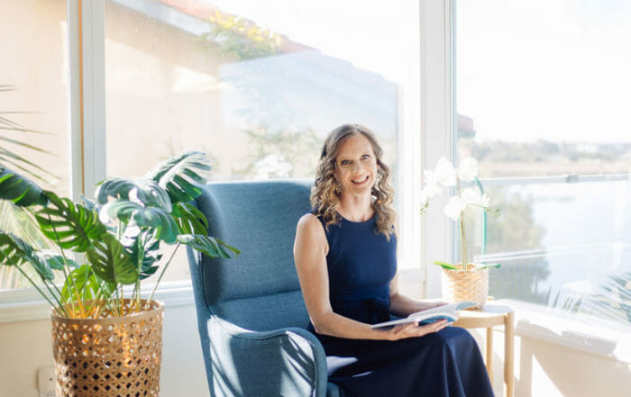 Lisa Gornall in blue dress with book to write about relationship success