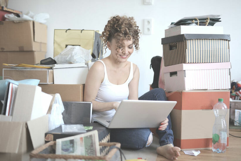 woman on computer surrounded by boxes