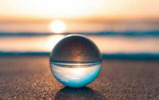 crystal on beach with reflection of ocean to demonstrate how to practice mindfulness now