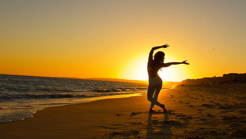 Kimberly Snyder on the beach at Sunset showing how to expand vitality