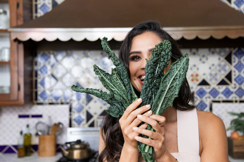 Kimberly Snyder in kitchen holding kale
