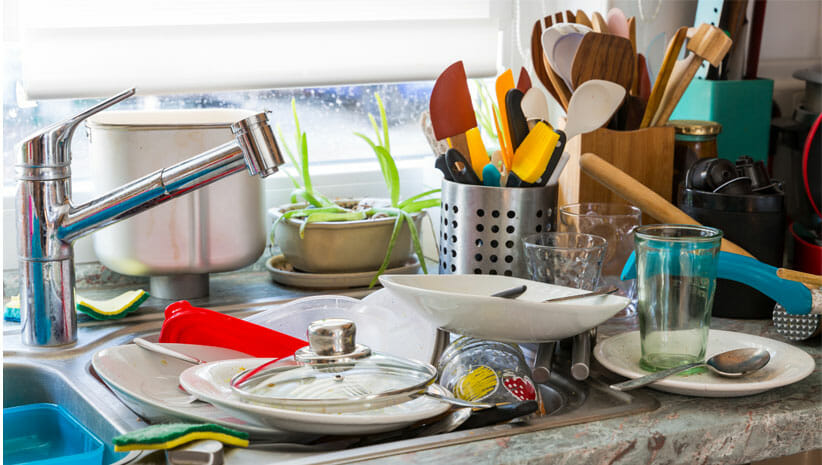 kitchen sink in a cluttered home filled with dishes