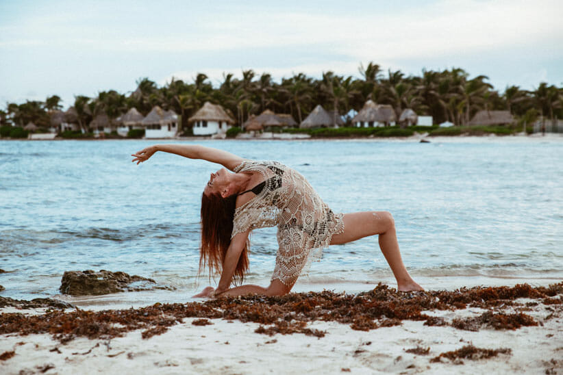 woman in yoga pose at the ocean
