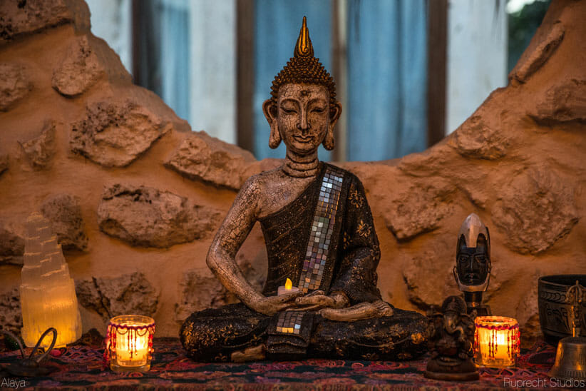 Thai Buddha statue with candles on cabinet