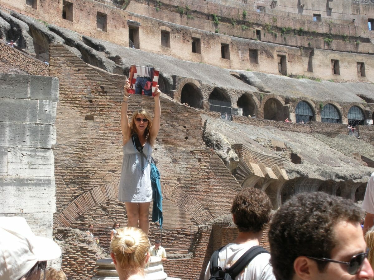 Woman standing in Rome Coliseum with album in hand