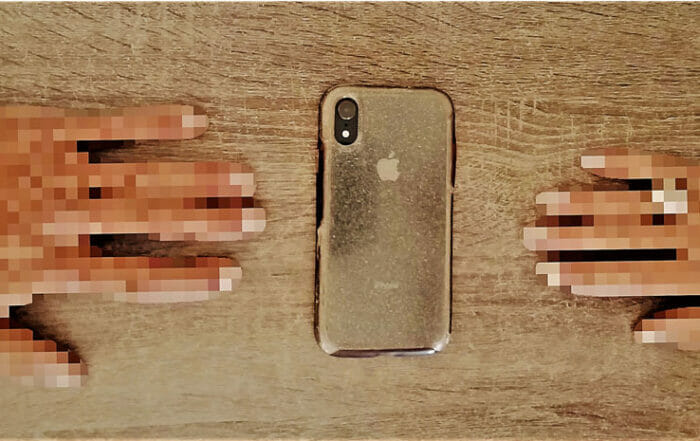 two pixelated hands reaching toward a phone in the middle of the screen