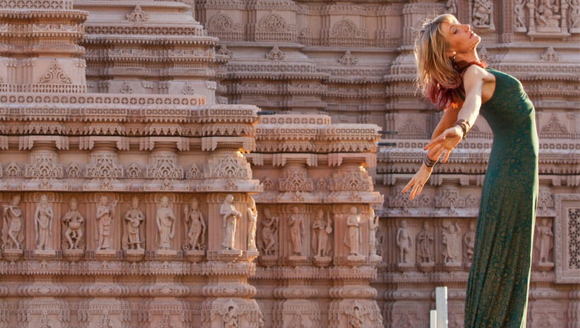Johanna Beekman arms raised in front of a temple from cover of Yoga Soundtracks Volume 2
