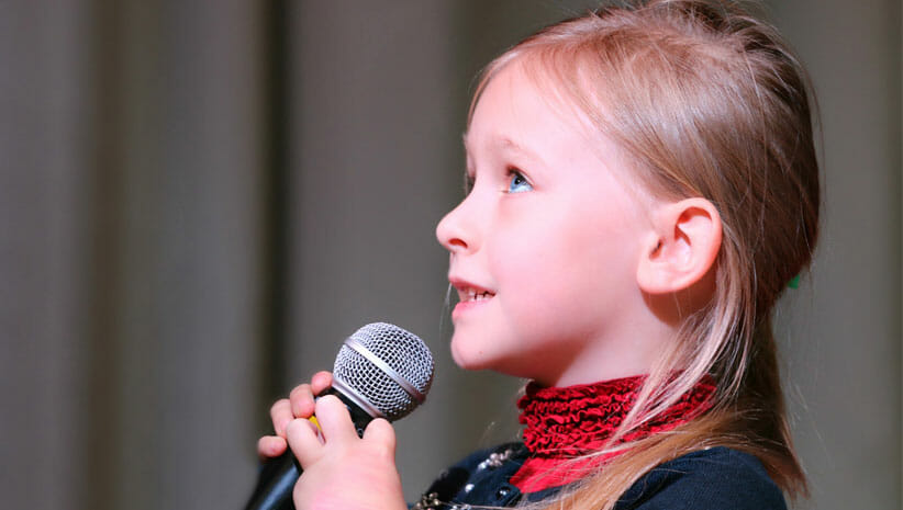 girl with blond hair with microphone 