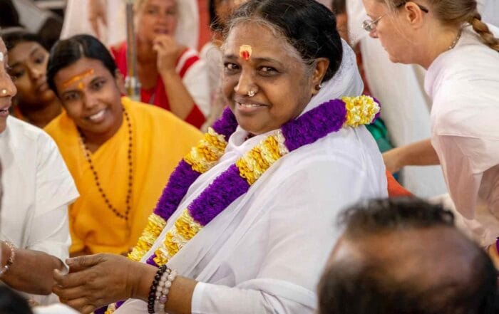 Picturing of Amma smiling purple and gold garland