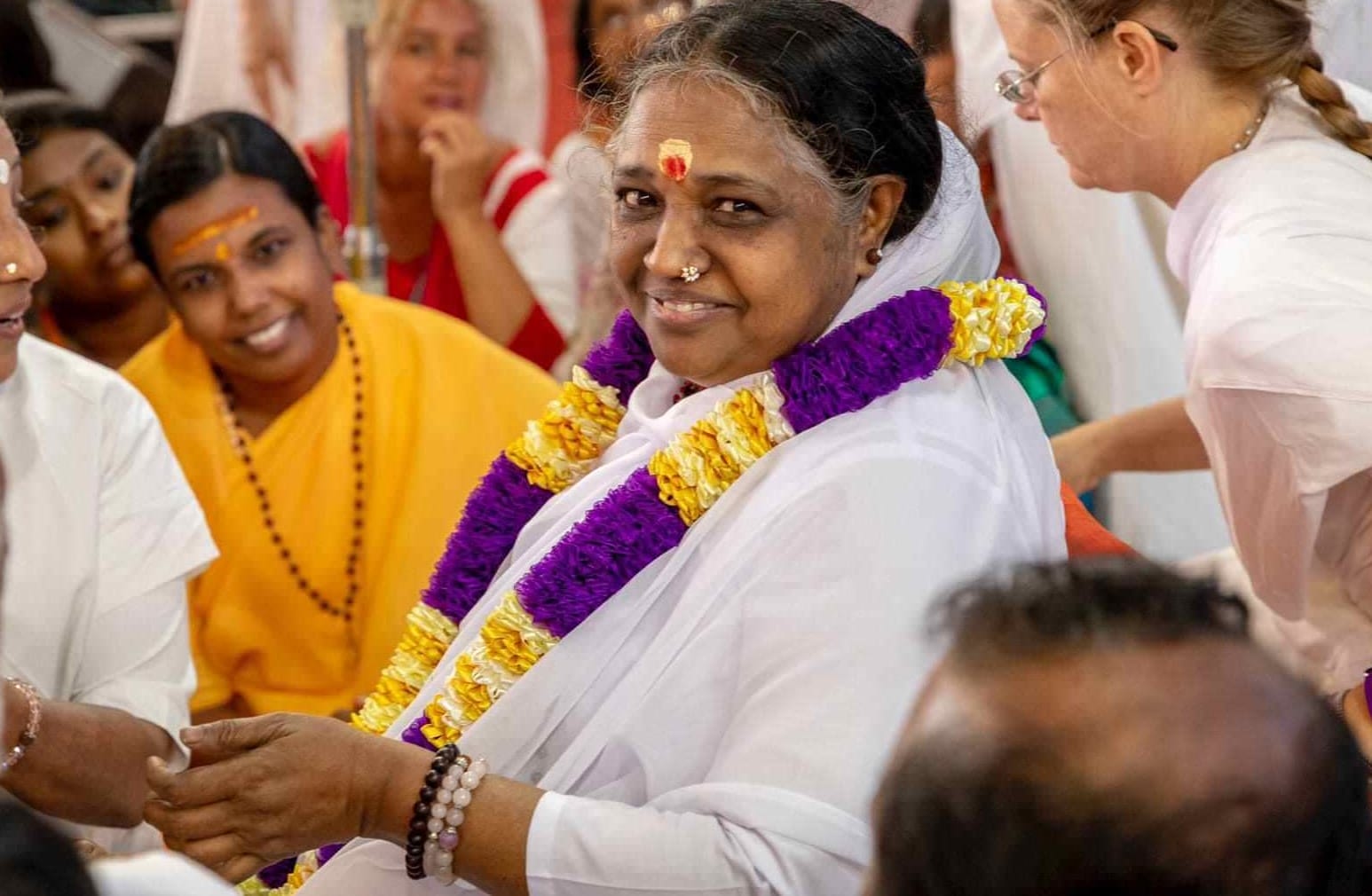 Picturing of Amma smiling purple and gold garland