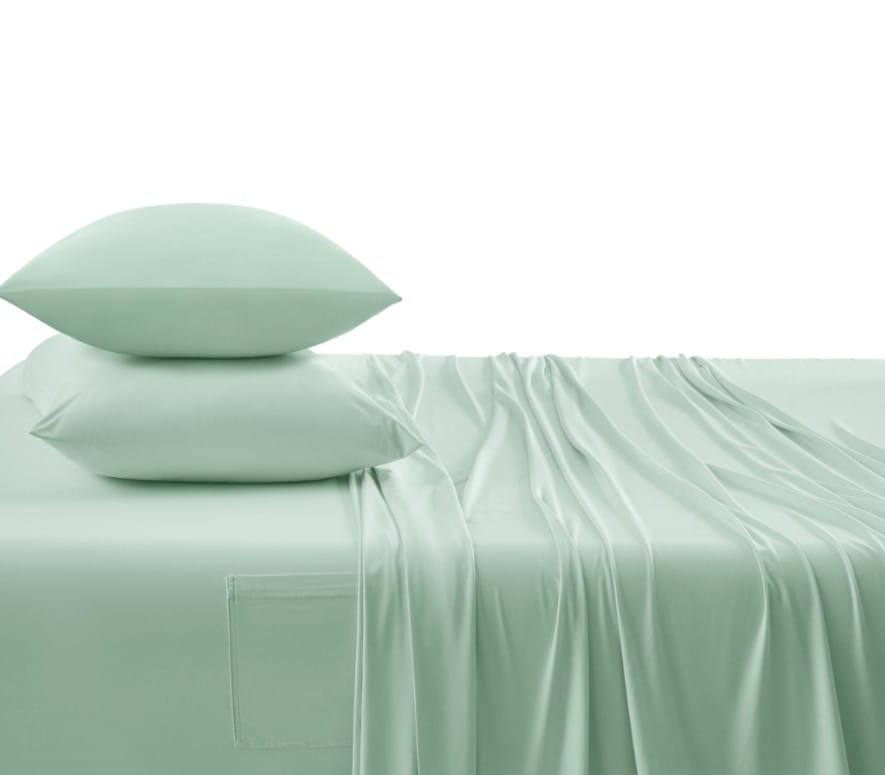 set of green sheets and pillowcases made up on a bed