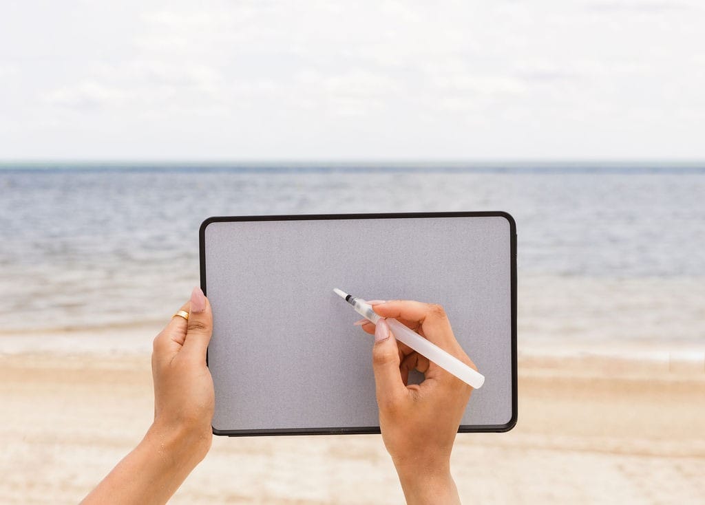 woman's hands holding Buddha Board Enso at the beach